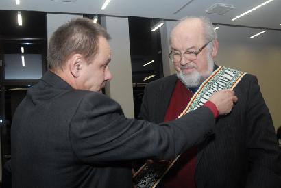 Anykščių rajono meras Sigutis Obelevičius rašytojui Algimantui Zurbai užrišo garbės juostą. Jono JUNEVIČIAUS nuotr.