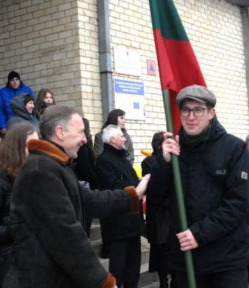 Minint valstybės atkūrimo 95 – ąsias metines Kurklių seniūnas Algimantas Jurkus valstybinę vėliavą įteikė ir akcijos nešti 95 vėliavas organizatoriui Norbertui Černiauskui (dešinėje). Jono JUNEVIČIAUS nuotr.