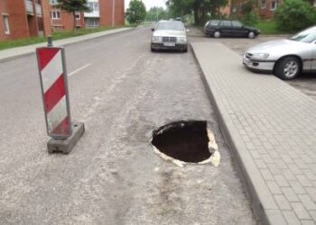 Apie atsivėrusią smegduobę vairuotojus įspėja kelio ženklas. Autoriaus nuotr.