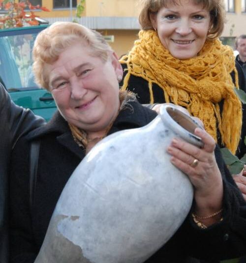 ŽŪB „Elma“ augalininkystės padalinio vadovė Janina Kisielienė (su ąsočiu) jaučia apmaudą, kad dauguma kaimiečių prezidento rinkimuose balsavo už konservatorių remiamą Dalią Grybauskaitę, bet ne už jos partietį, Ignalinos rajono merą Bronį Ropę. Valstiečių ir žaliųjų sąjungos narė J.Kisielienė, trūkus vandentiekiui, kaimo gyventojus galėtų pagirdyti bent jau iš ąsočio.Autoriaus nuotr.