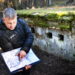 Prie šio didelio bunkerio miške jau sutvarkyta aplinka, o Ramūnas Keršys rodo Pirmojo pasaulinio karo fronto žemėlapį.