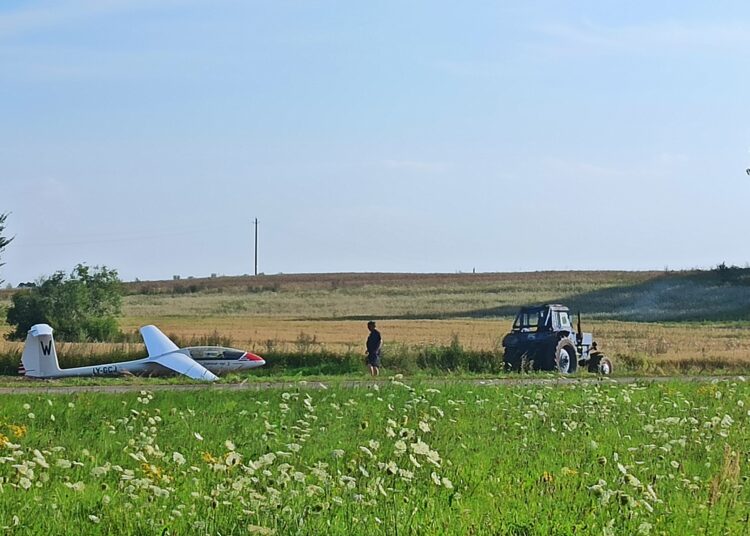 Dulkant žemei iš po traktoriaus ratų paskui jį „skrido“ sklandytuvas.