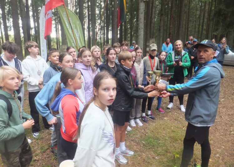 Anykščių sporto centro direktorius Arvydas Krikščiūnas apdovanoja gausiausiai dalyvavusią Anykščių A. Baranausko pagrindinės mokyklos komandą. 		           Autoriaus nuotr.