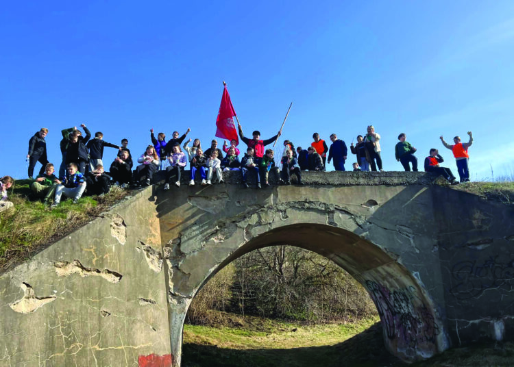Anykščių Antano Baranausko pagrindinės mokyklos žygeiviai ant geležinkelio tilto arkos.